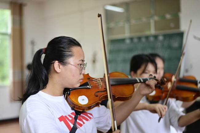 Οι μαθητές εξασκούνται στα βιολιά τους στην τάξη μουσικής ενός γυμνασίου στην κομητεία Τσονγκτζιάνγκ, στην επαρχία Γκουιτζόου της Νοτιοδυτικής Κίνας. [Φωτογραφία / chinadaily]