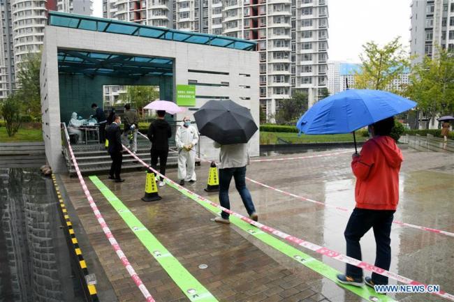 Άνθρωποι περιμένουν να κάνουν COVID-19 τεστ σε ένα σημείο για τεστ στην πόλη Τσινγκντάο, στην επαρχία Σαντόνγκ της ανατολικής Κίνας, στις 14 Οκτωβρίου 2020. (φωτογραφία / Xinhua)