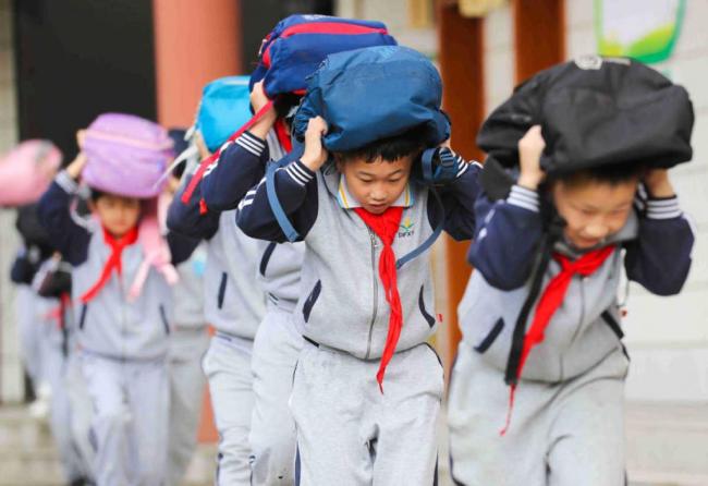 Μαθήτες παίρνουν μέρος σε άσκηση κατά των σεισμών σε ένα δημοτικό σχολείο του Χουτζόου στην επαρχία Τζετζιάνγκ στις 12 Οκτωβρίου 2020, μια μέρα πριν από την Διεθνή Ημέρα Μείωσης των Καταστροφών. <br>