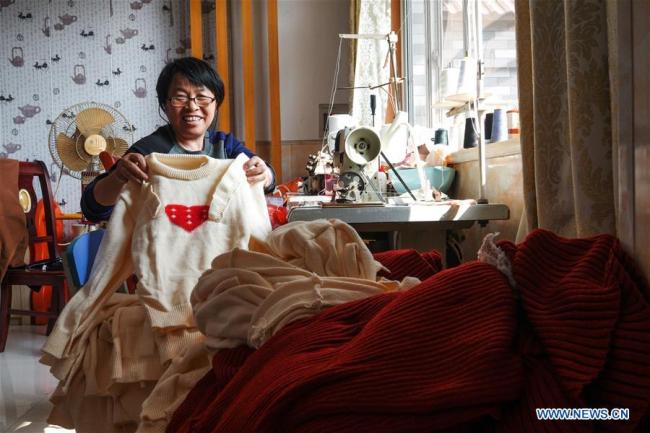 Η Χου Φεν δείχνει ένα μάλλινο πουλόβερ που έφτιαξε από το σπίτι της στο χωριό Καϊσιανχόνγκ της περιοχής Γουτζιάνγκ στο Σουτζόου, στην επαρχία Τζιανγκσού της ανατολικής Κίνας, 17 Οκτωβρίου 2020.