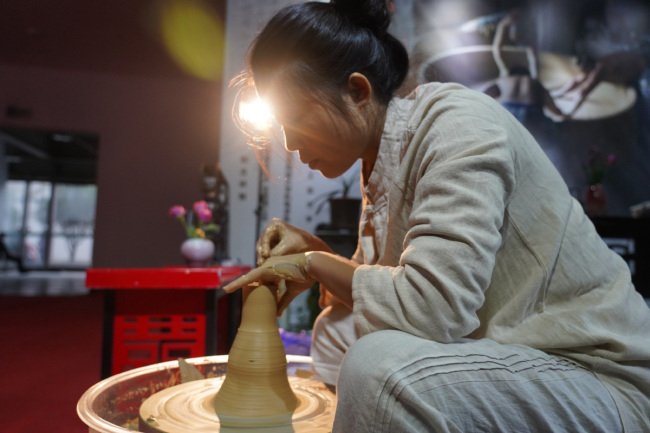 Μια καλλιτέχνης επιδεικνύει τις τεχνικές κατασκευής πορσελάνης κατά τη διάρκεια της Διεθνούς Έκθεσης Κεραμικής στο Τζινγκντετζέν, επαρχία Τζιανγκσί, 18 Οκτωβρίου 2020. [Φωτογραφία / Xinhua]