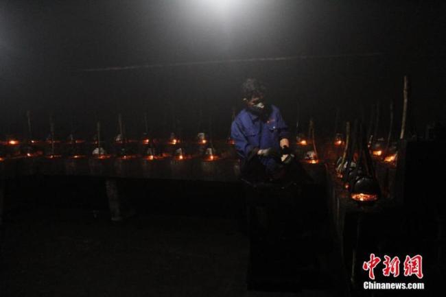Τεχνίτης επιδεικνύει τη διαδικασία σκλήρυνσης του καπνού σε πλακίδια, σε ένα εργαστήριο στην κομητεία Σεσιάν, στην επαρχία Ανχούι της ανατολικής Κίνας, σε φωτογραφία από τις 15 Οκτωβρίου 2020. (Φωτογραφία / Υπηρεσία ειδήσεων της Κίνας)