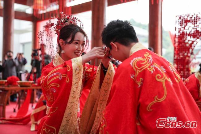 Η νύφη κόβει λίγα μαλλιά από το κεφάλι του γαμπρού σε μια παραδοσιακή κινεζική γαμήλια τελετή που διοργανώθηκε στο Γκουιγιάνγκ της επαρχίας Γκουιτζόου, στις 16 Νοεμβρίου 2020. (φωτογραφία/ China News Service)