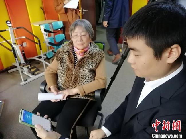 Ο Σουν Γιουανμίνγκ, ο υπεύθυνος για το πρόγραμμα προσαρμοσμένων ανάλογα με την περίπτωση έξυπνων βραχιολιών, παρουσιάζει τη χρήση ενός από αυτά. (Chinanews.com/Li Jie) 