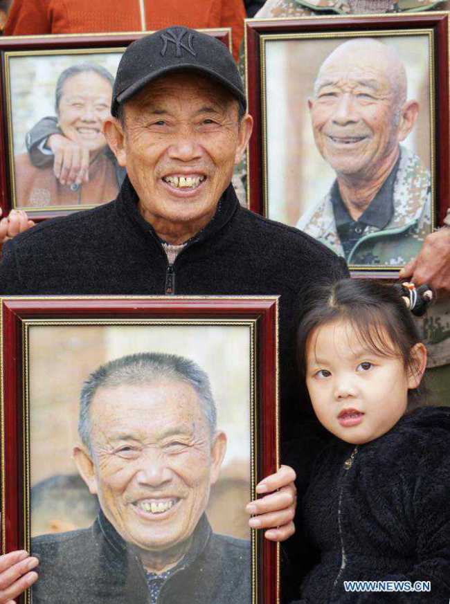 Ένας χωρικός χαμογελά καθώς κρατά τη φωτογραφία του στο χωριό Λουοσέ της περιοχής Γιοουλάν, κοντά στην πρωτεύουσα Ναντσάνγκ, στην επαρχία Τζιανγκσί της ανατολικής Κίνας, στις 22 Νοεμβρίου 2020.