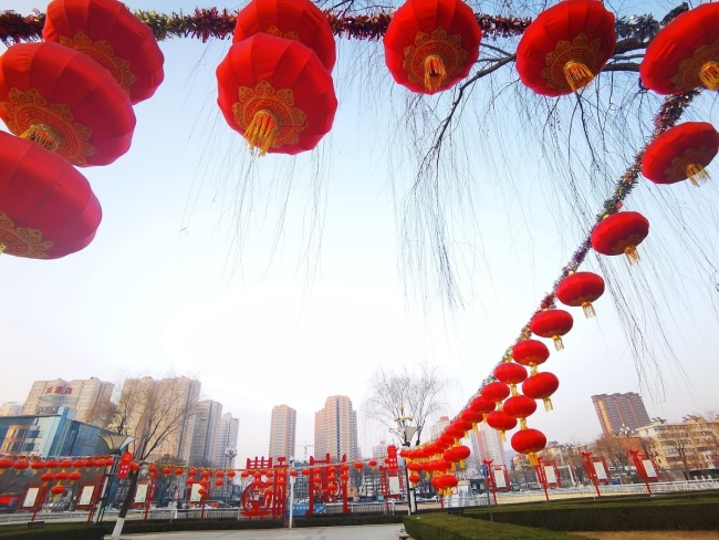 Μια πλατεία στο Μπαοτζί, στην επαρχία Σαανσί της βορειοδυτικής Κίνας, είναι διακοσμημένη με κόκκινα φανάρια (灯笼 dēnglong) και κινεζικούς κόμπους (中国 结 zhōngguójié) στις 9 Φεβρουαρίου 2021. [Φωτογραφία: VCG]