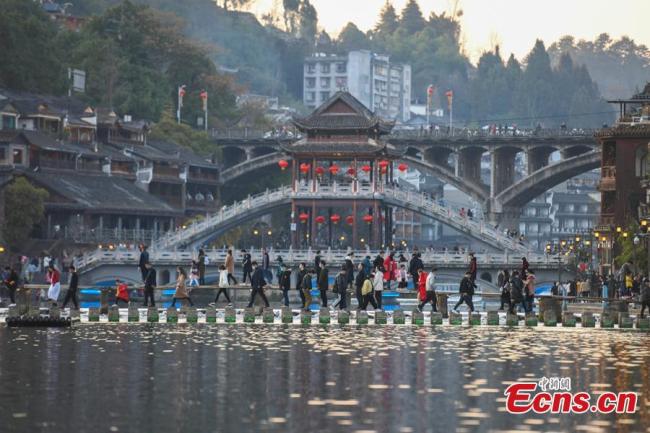 Η φωτογραφία που ελήφθη στις 16 Φεβρουαρίου 2021 δείχνει τους τουρίστες να επισκέπτονται την πόλη Φενχουάνγκ στον αυτόνομο νομό των Σιανγκσί Τουτζιά και Μιάο, στην επαρχία Χουνάν της Κεντρικής Κίνας.