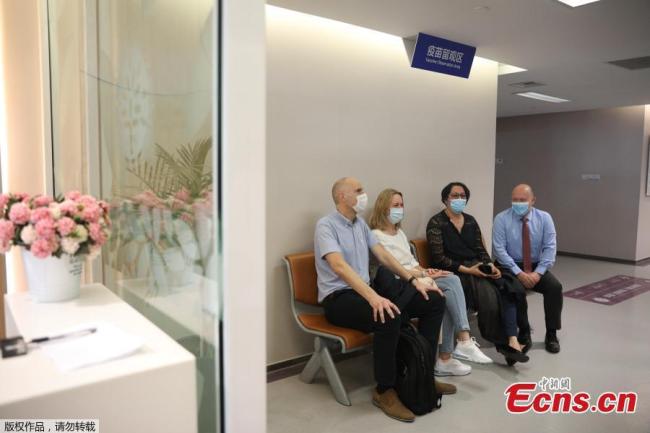 Αλλοδαποί κάτοικοι της Σαγκάης κάθονται στην αίθουσα παρατήρησης για 30 λεπτά αφότου έλαβαν το εμβόλιο, στην Σαγκάη, 29 Μαρτίου 2021.