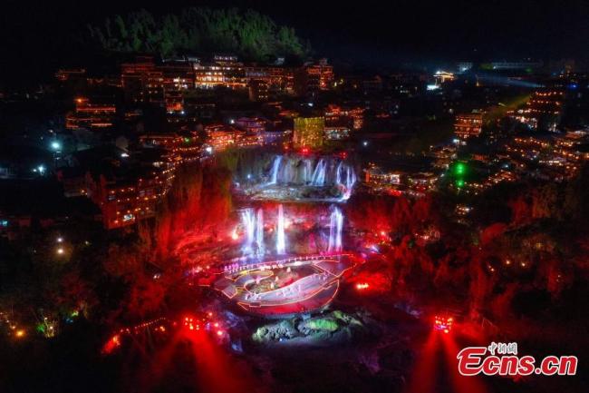 Η φωτογραφία που τραβήχτηκε στις 31 Μαρτίου 2021, δείχνει την γιορτινή άποψη ενός τοπίου βράχων με καταρράκτη το βράδυ, στην πόλη Φουρόνγκ, στην επαρχία Χουνάν της κεντρικής Κίνας. (Φωτογραφία: China News Service)
