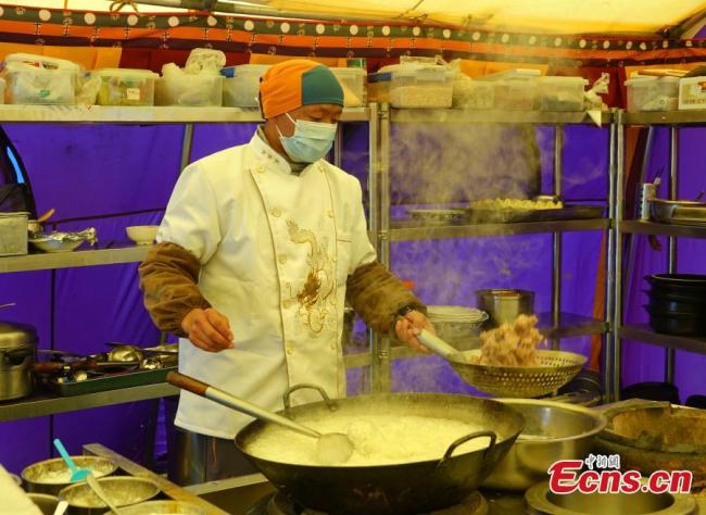 Ένας σεφ φτιάχνει αρνί με κύμινο στην Κατασκήνωση Βάσης στη βόρεια πλαγιά του όρους Τσομολάνγκμα, 9 Μαΐου 2021. (Φωτογραφία: China News Service)