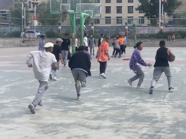 Η Σίγλα, δεύτερη από δεξιά, παίζει μπάσκετ στο 2ο Λύκειο Νανγκτσού στη Λάσα, πρωτεύουσα της αυτόνομης περιοχής του Θιβέτ της Νοτιοδυτικής Κίνας, την 1η Ιουνίου 2021. [Φωτογραφία / Xinhua]