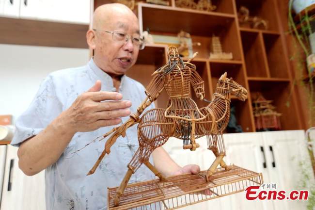 Στην φωτογραφία ο Τζινγκ παρουσιάζει το μοντέλο από μπαμπού του στρατηγού Γκουάν Γιου, μιας από τις πιο διάσημες κινεζικές αρχαίες προσωπικότητες, στο Σι’αν, στην επαρχία Σαανσί της βορειοδυτικής Κίνας, 4 Αυγούστου 2021. (Φωτογραφία: China News Service)
