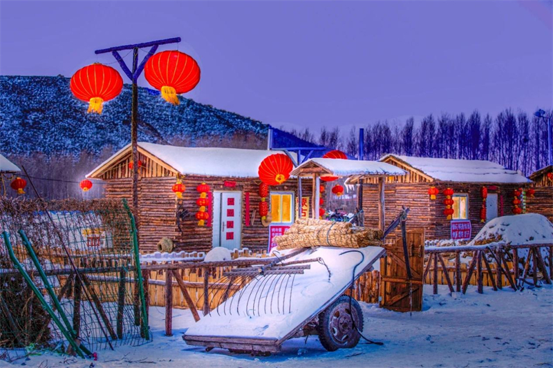 Ένα χιονισμένο χωριό στην Εσωτερική Μογγολία φωτίζεται από κόκκινα φανάρια το βράδυ. [Φωτογραφία/Δίκτυο Ειδήσεων της Εσωτερικής Μογγολίας]