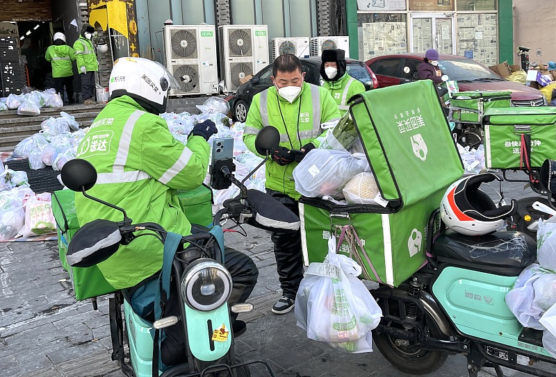 Punonjës të postës së shpejtë në një pikë dërgimi ushqimesh në distriktin Dongcheng të Pekinit, 17 dhjetor 2022. / CFP