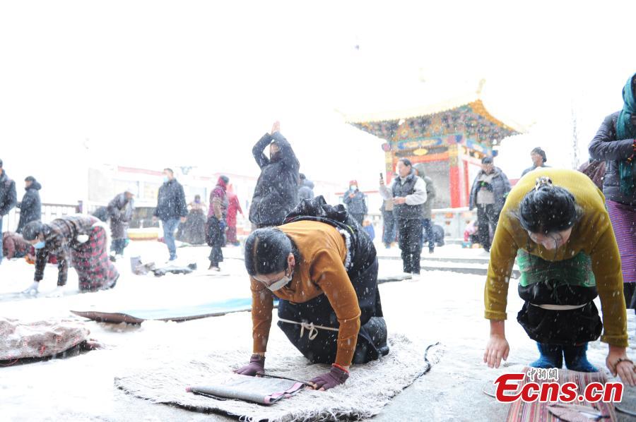 Θιβετιανοί προσκυνητές προσεύχονται μπροστά στον ναό Τζοκάνγκ μετά το χιόνι στη Λάσα, στην αυτόνομη περιοχή Σιζάνγκ (Θιβέτ) της νοτιοδυτικής Κίνας, 18 Ιανουαρίου 2024. (Φωτογραφία/China News Service)