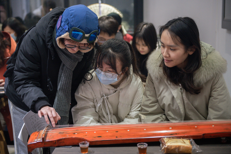 Οι μαθητές μαθαίνουν να παίζουν γκουτσίν, ένα κινεζικό μουσικό όργανο επτά χορδών, κατά τη διάρκεια μιας βραδινής σχολικής τάξης στην περιοχή Τζιανγκσιά του Γουχάν, στην επαρχία Χουμπέι της Κεντρικής Κίνας, 15 Δεκεμβρίου 2023. [Φωτογραφία/Xinhua]