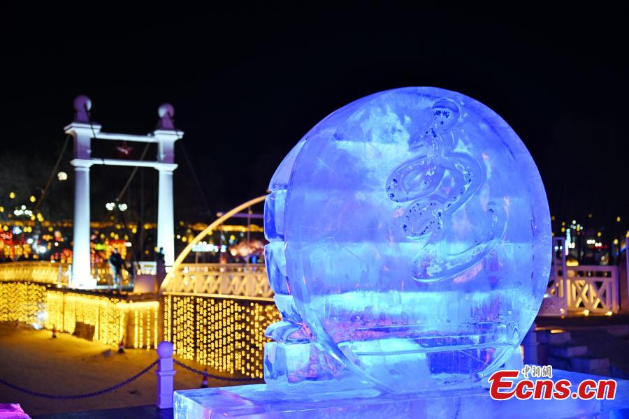 Ένα γλυπτό πάγου με θέμα τους 14ους Εθνικούς Χειμερινούς Αγώνες φωτίζεται στην πόλη Ζαλαντούν που φιλοξενεί τους αγώνες, στην αυτόνομη περιφέρεια της Εσωτερικής Μογγολίας της βόρειας Κίνας, 25 Φεβρουαρίου 2024. (Φωτογραφία: China News Service/Liu Huawen)
