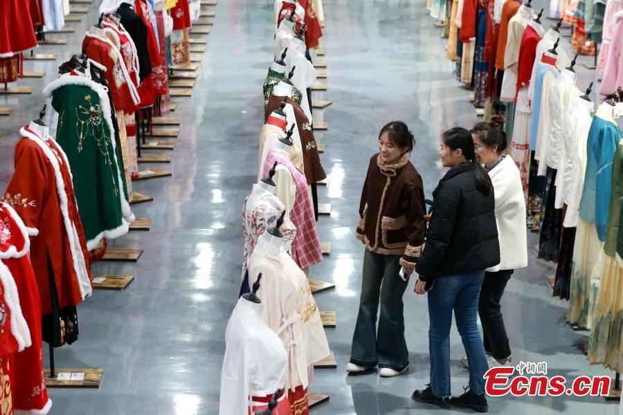 Πελάτες επιλέγουν φούστες ‘μαμιεντσούν’ σε ένα εργοστάσιο ένδυσης στην κομητεία Τσαοσιέν,  στην επαρχία Σανντόνγκ της ανατολικής Κίνας, 4 Μαρτίου 2024. (Φωτογραφία: China News Service/Liang Ben)