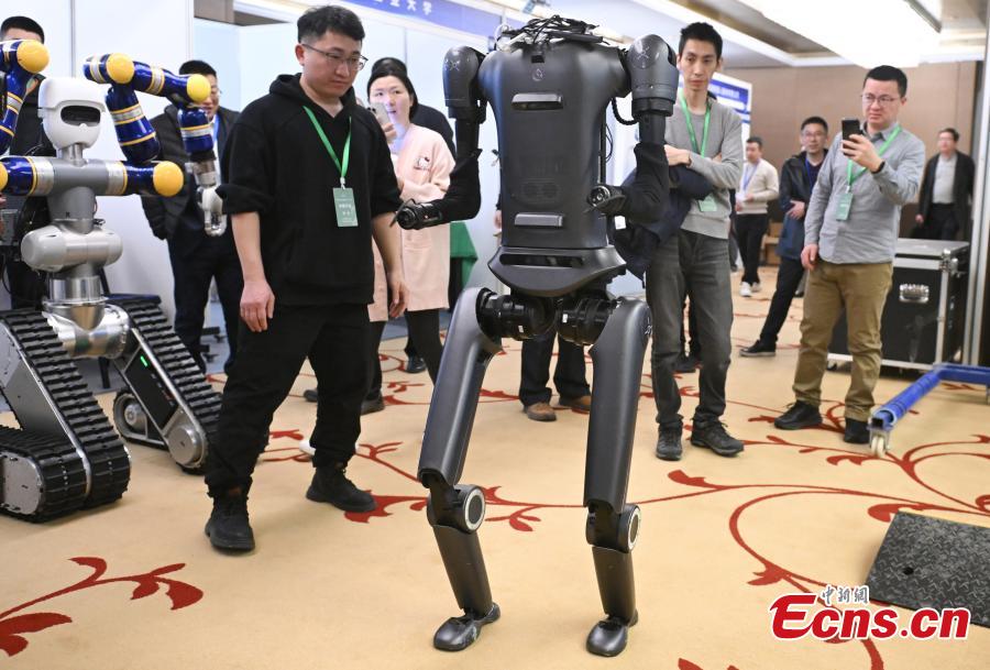 Ένας διαγωνιζόμενος δείχνει πώς λειτουργεί ένα ανθρωπόμορφο ρομπότ στον Διαγωνισμό Ανθρωπόμορφων Ρομπότ που πραγματοποιήθηκε στην Οικονομική-Τεχνολογική Περιοχή Ανάπτυξης του Πεκίνου, στις 13 Μαρτίου 2024. (Φωτογραφία: China News Service)